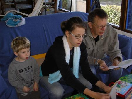 Nathan, Enora et grand-p�re �tudient une r�gle du jeu  